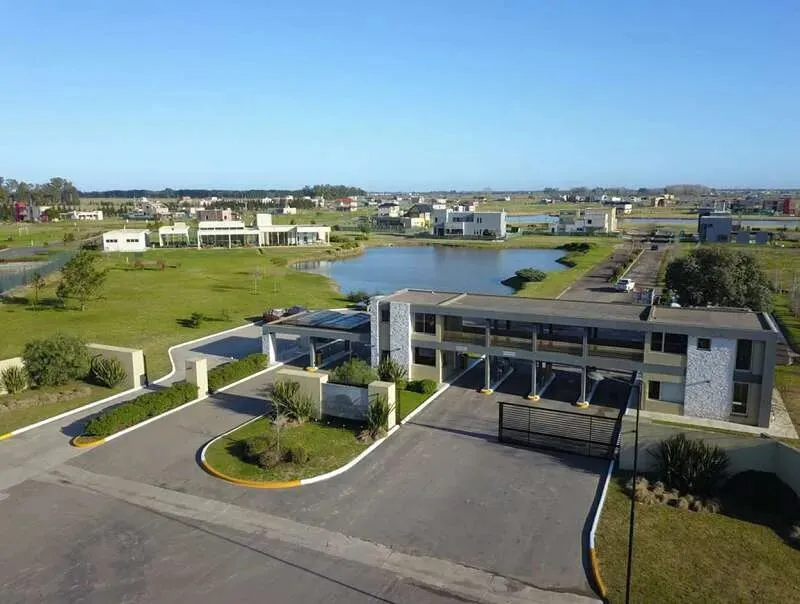 Vista aérea de un barrio cerrado de Canning, con laguna y casas alrededor